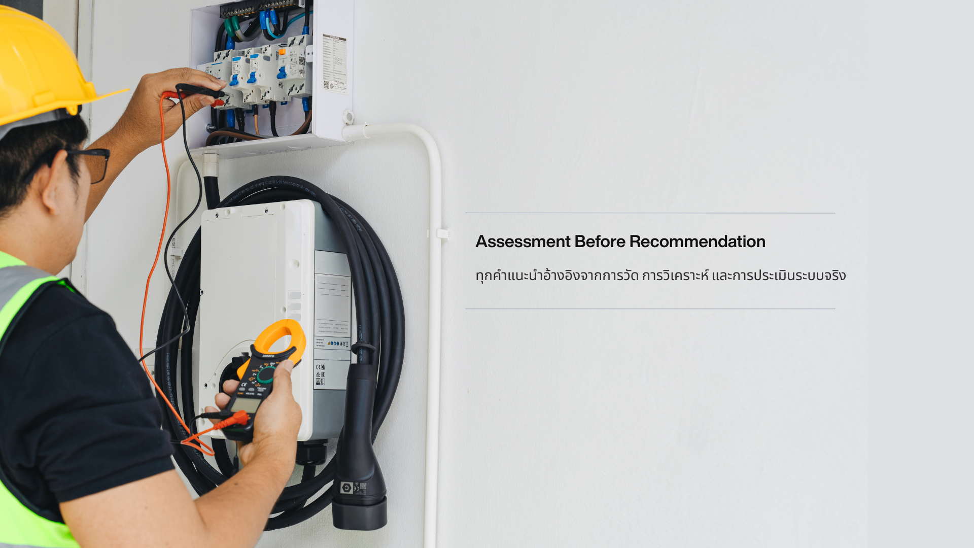 Residential engineer measuring current on a home consumer unit with a True RMS clamp meter, referencing a tablet-based inspection checklist